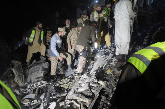 جنود ومتطوعين باكستانيين فى محيط سقوط طائرة ركاب تابعة للخطوط الجوية الباكستانية