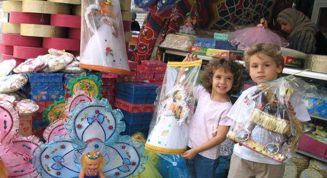 أطفال يحملون عروسة المولد