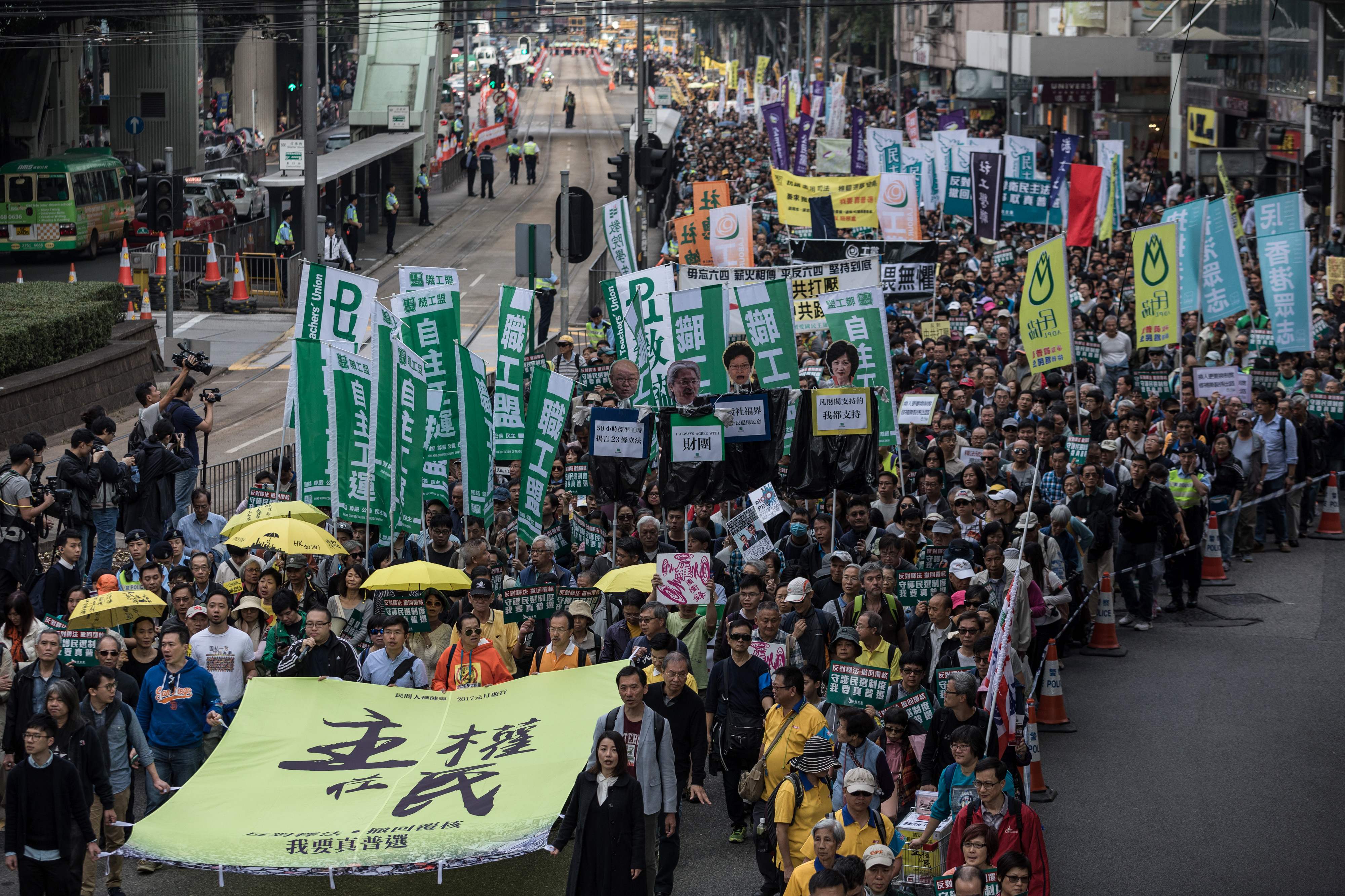صينيون حاملون لافتة بعنوان السيادة للشعب فى مظاهرة ضد الصين بهونج كونج