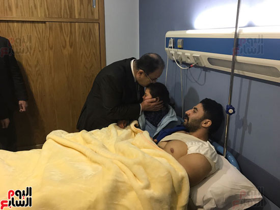 وزير الداخلية يقبل طفل من أقارب أحد الجنود المصابين