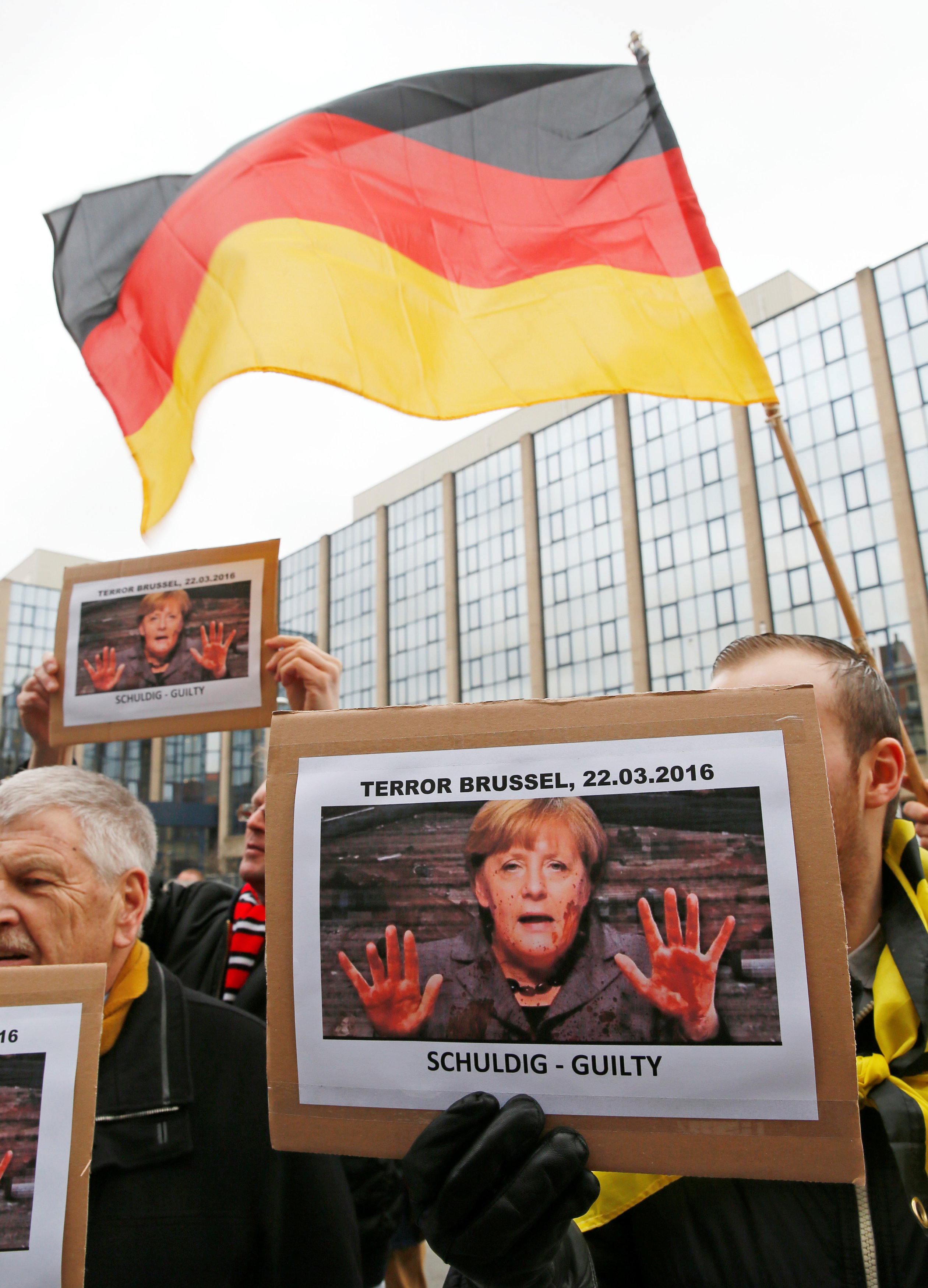 المتظاهرون يرفعون علم ألمانيا وصور المستشارة انجيلا ميركل