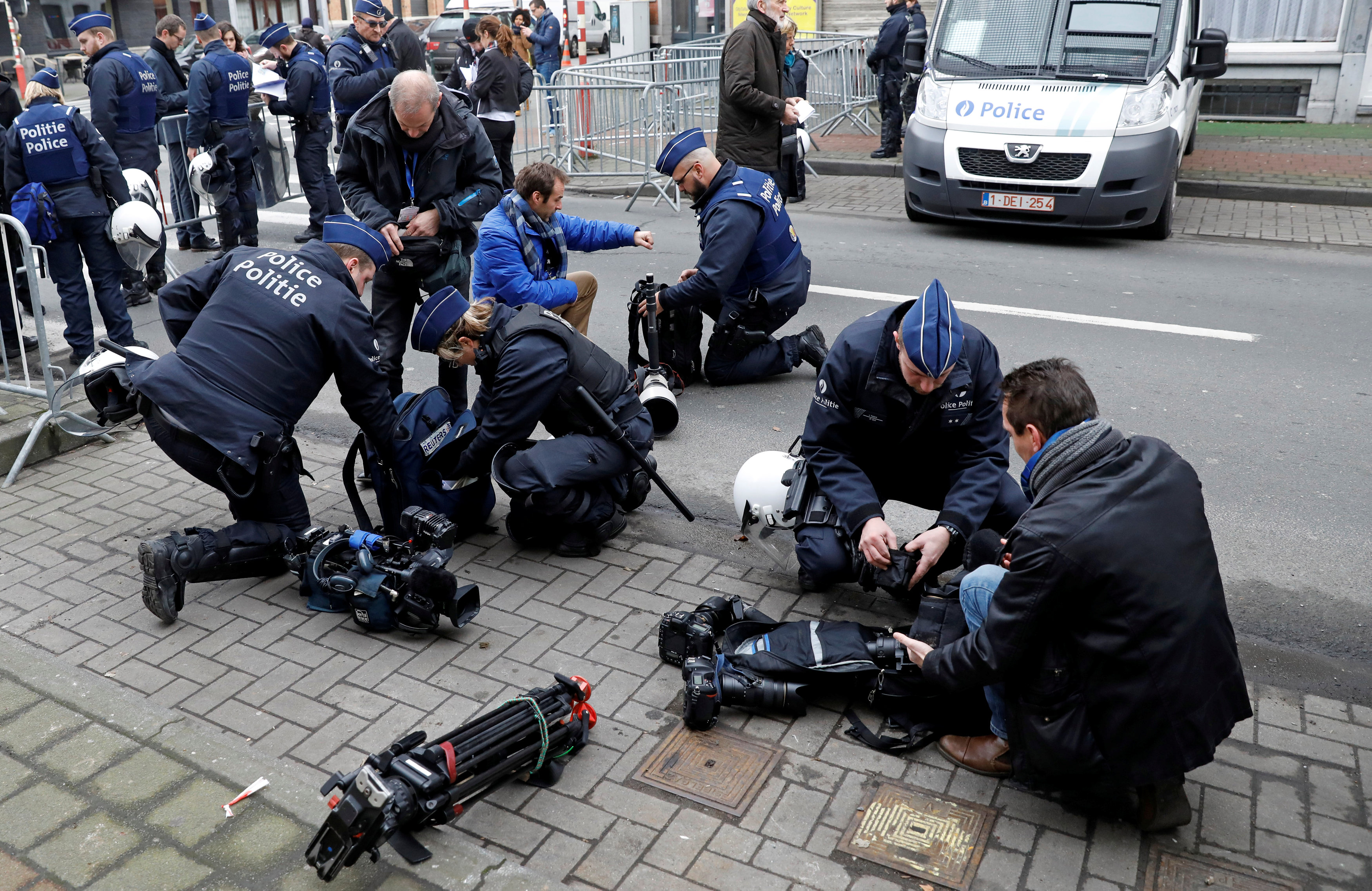 أفراد الأمن يفتشون معدات وسائل الإعلام على مدخل مقر وصول المستشار الألمانية