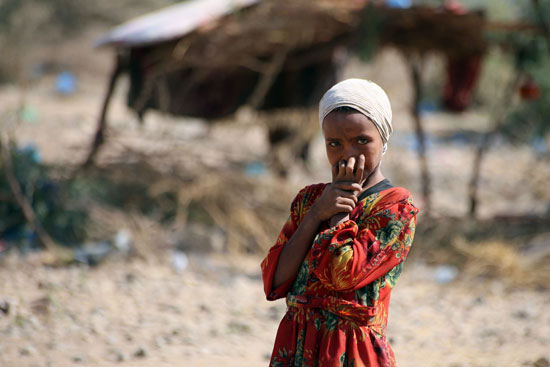 طفلة يمنية تقف داخل مخيم اللاجئين فى تعز