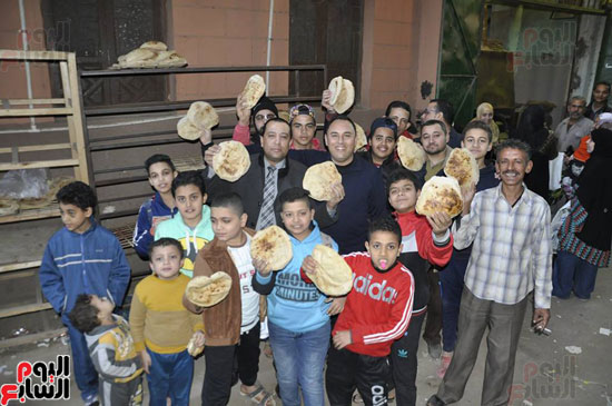 الزميل أحمد عبد الهادى بكير والمواطنون وصاحب المخبز يلتقطون صورة تذكارية