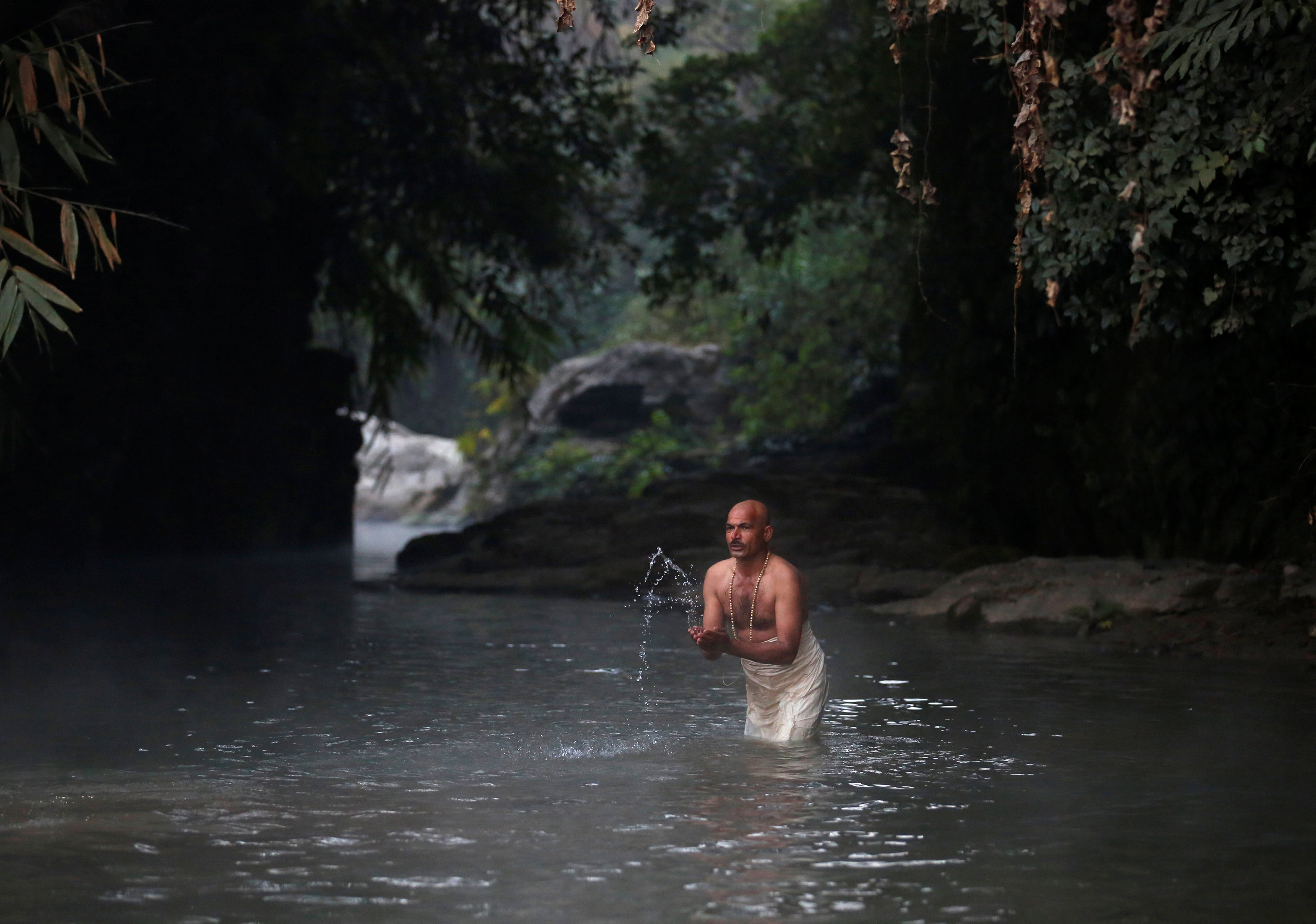 مواطن يحتفل بالمهرجان الهندوسى بالسباحة فى نهر هانومانتى