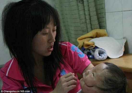ام الطفل الصيني تتفحص وجهه