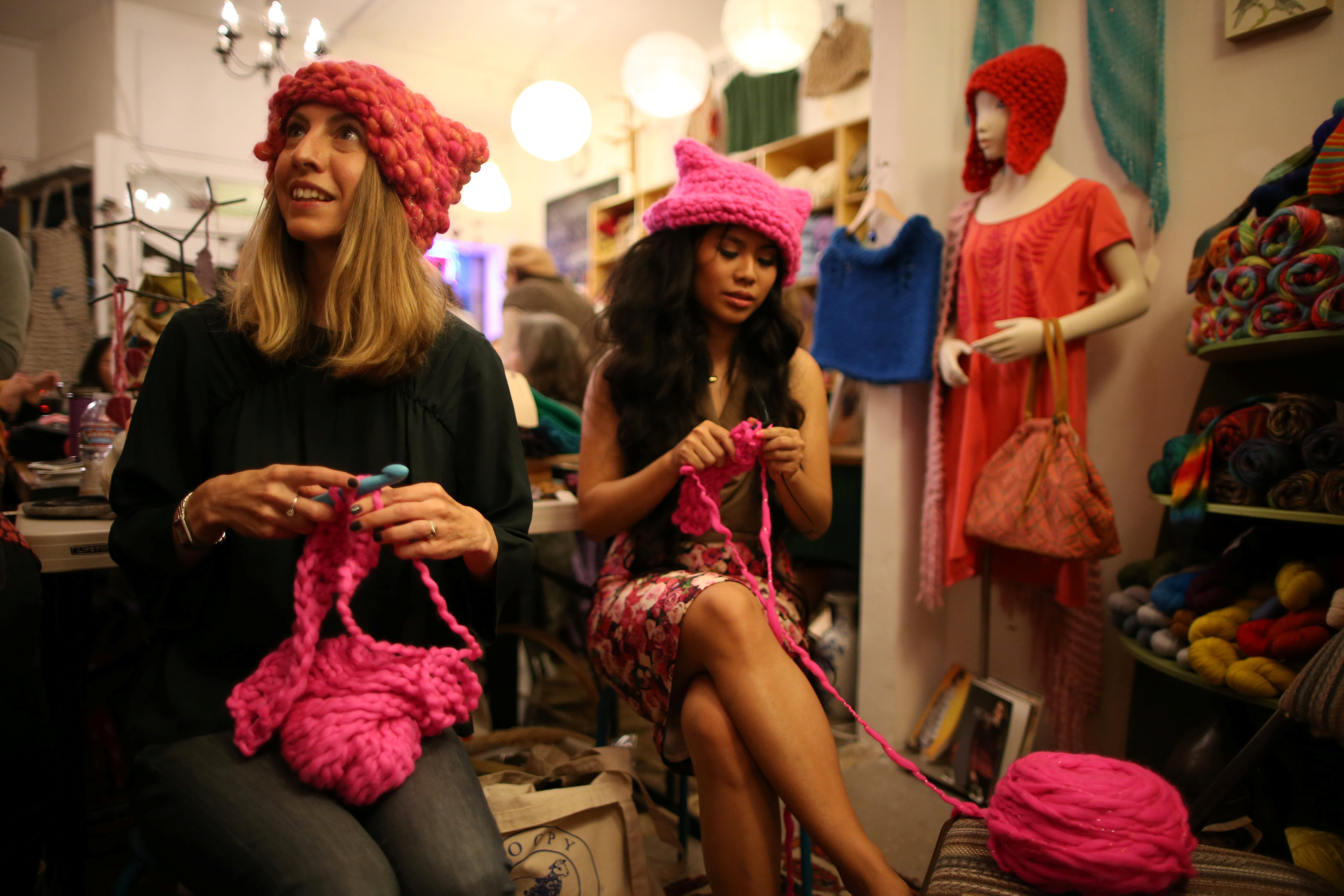 فتيات يشاركن فى تصنيع قبعات وردية استعدادًا للمسيرة النسائية ضد ترامب