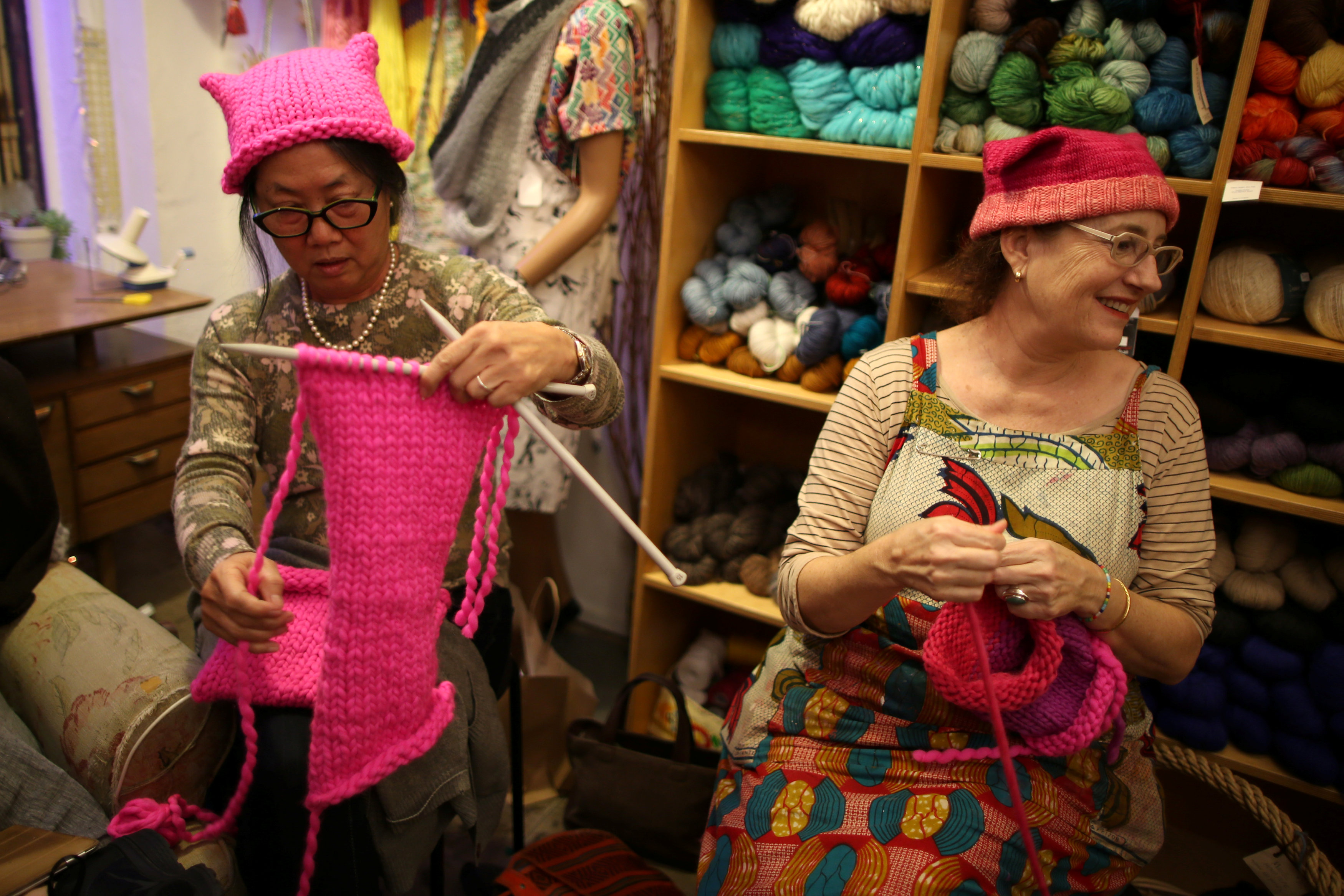 السيدات المشاركات فى الإعداد للمسيرة يتبادلن الضحك أثناء تصنيع القبعات