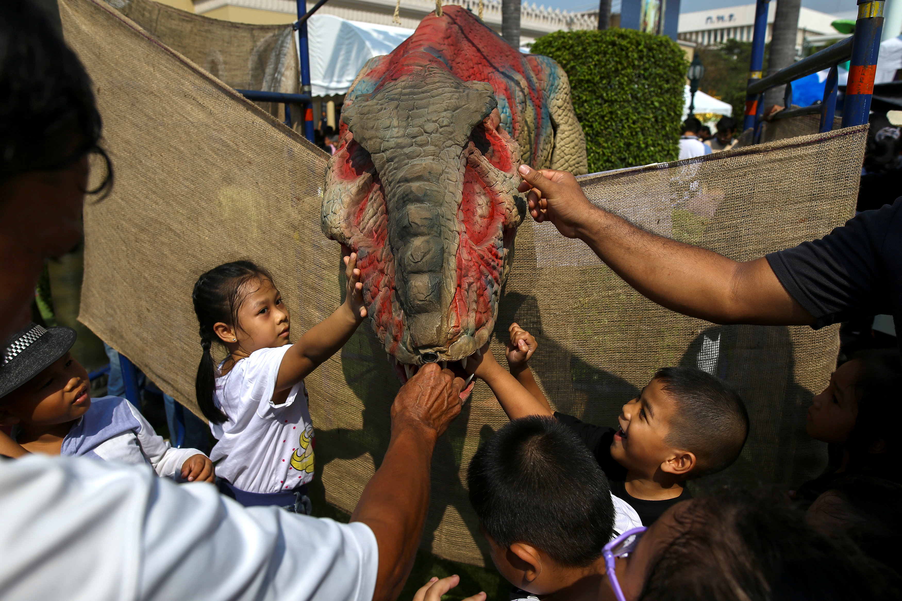 الأطفال يلعبون مع تمثال دنياصور فى مقر الحكومة