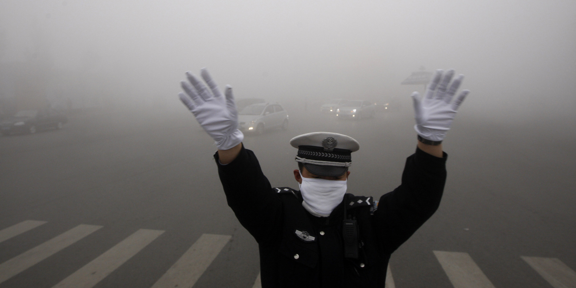 ضابط مرور أثناء أداء عمله فى الضباب الدخانى ببكين