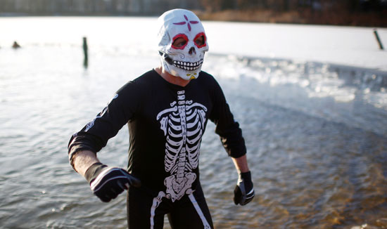 رجل مقنع يخرج من البحيرة الجليدية خلال احتفالات كرنفال السباحة ببرلين