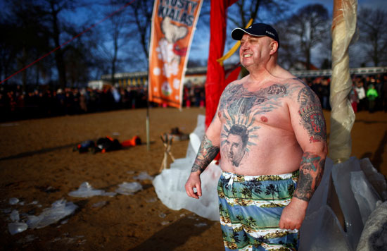 صورة تذكارية لرجل ضخم يرسم وشم على جسده خلال احتفالات كرنفال السباحة ببرلين