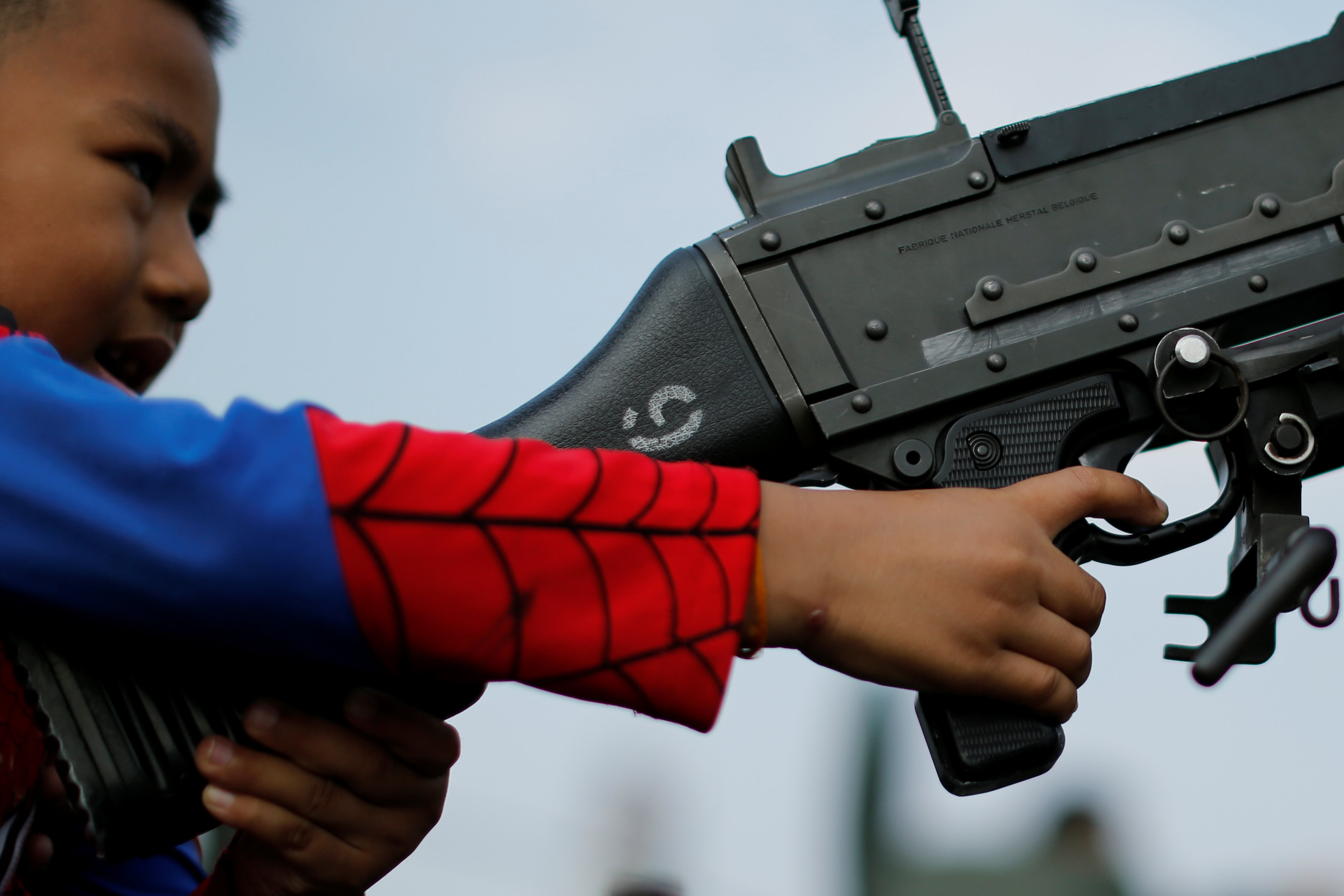 طفل يرتدى زى سبايدر مان ويمسك بسلاح فى احتفالات يوم الطفل بتايلاند