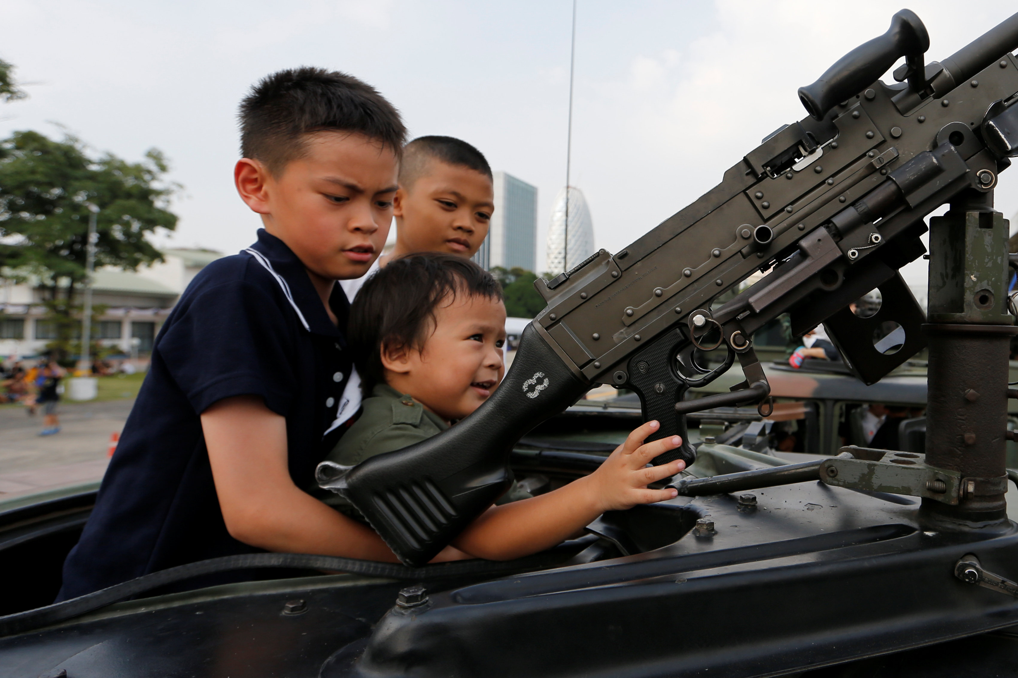 الأطفال يلهون داخل السيارة المصفحة خلال احتفالات يوم الطفل بمقر الحكومة التايلاندية