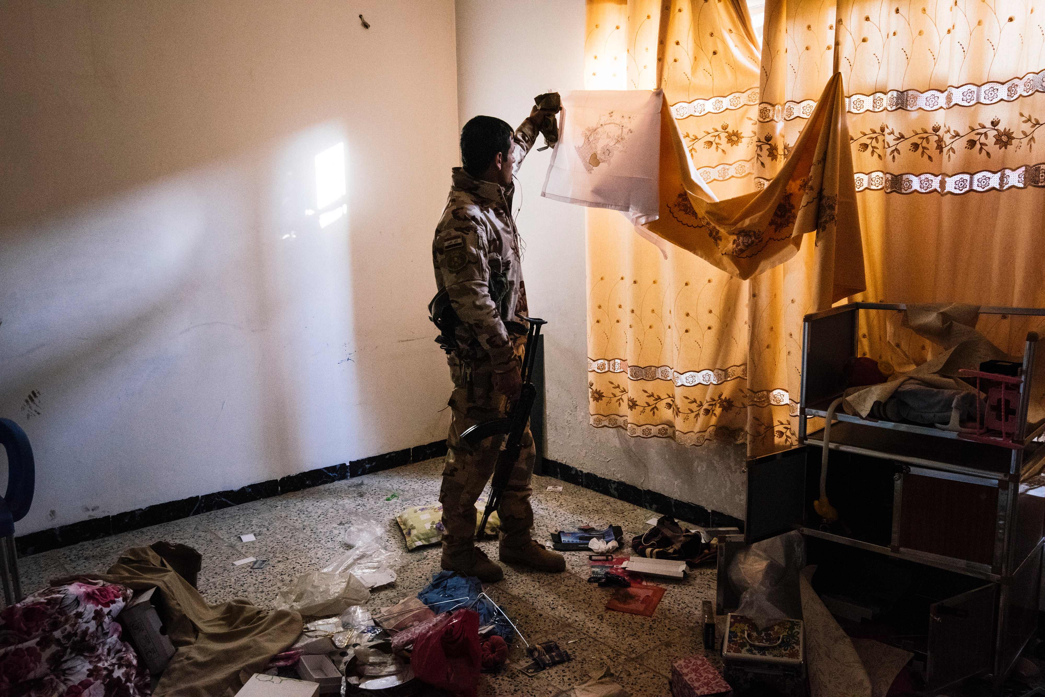 أحد عناصر الجيش العراقى يتفقد منزل كان يتحصن به المسلحين