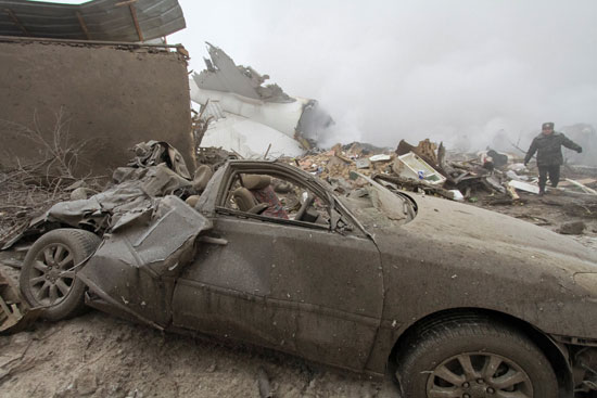 سيارة ومنزل مهدم أثر سقوط طائرة الشحن التركية فى منطقة مأهولة بالسكان بقيرغزستان