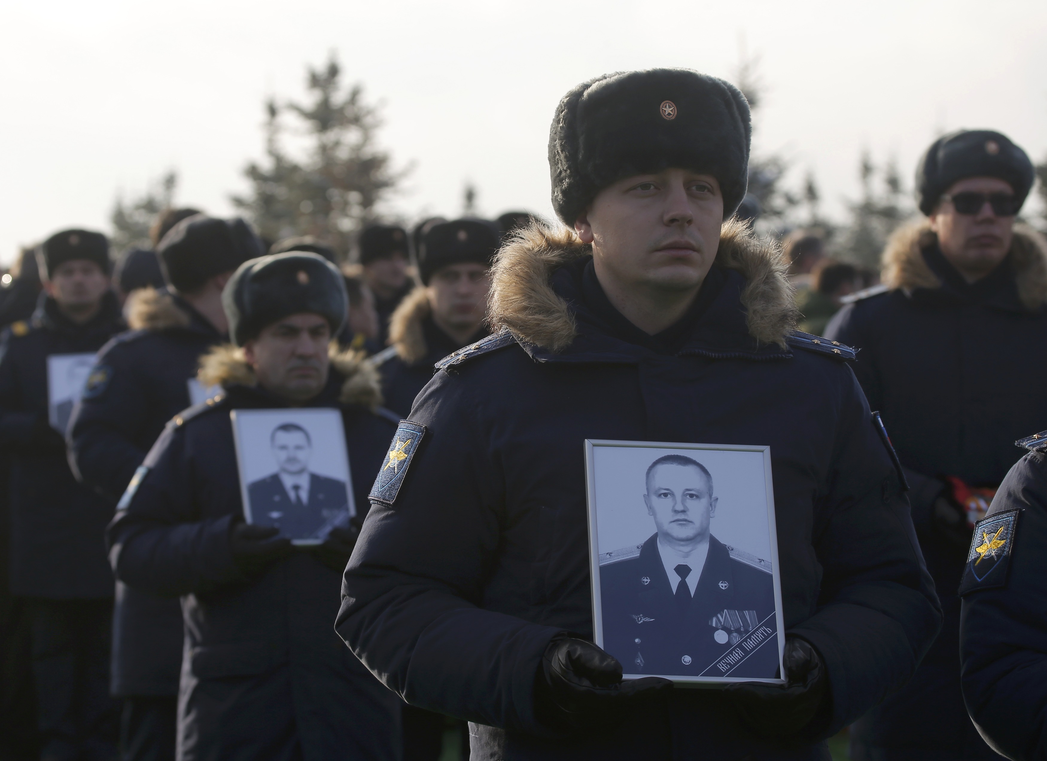 جنود يحملون صور ضحايا الطائرة العسكرية الروسية