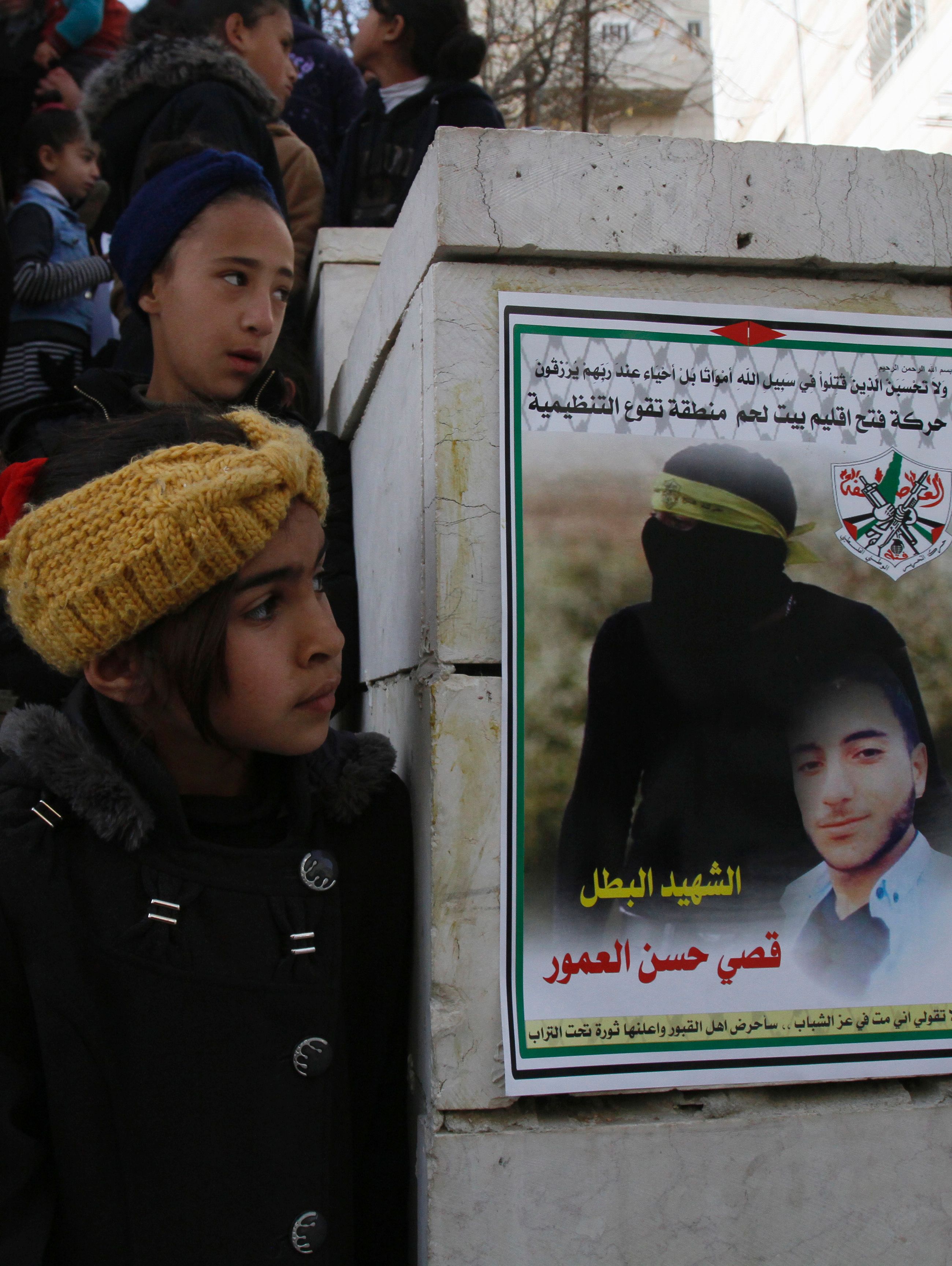 أطفال يقفون بجانب صوره للشهيد قصى خلال تشييع جثمانه - أ ف ب