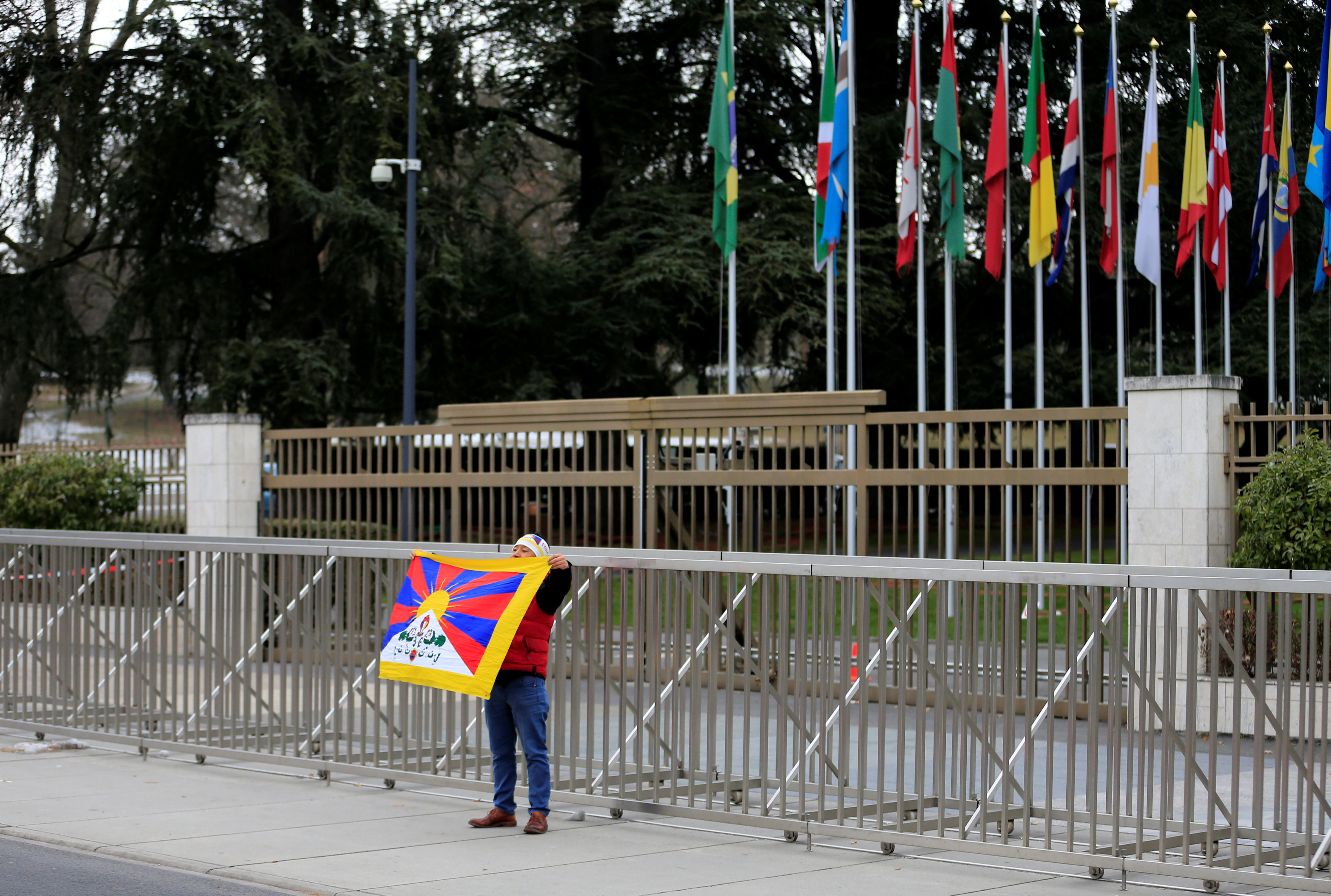 متظاهر صينى ضد رئيس بلاده يقف أمام مقر الأمم المتحدة فى جنيف