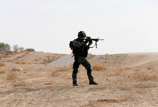 	جندى اسرائيلى يصوب سلاحه باتجه الفلسطينيين بقرية أم الحيران الفلسطينية