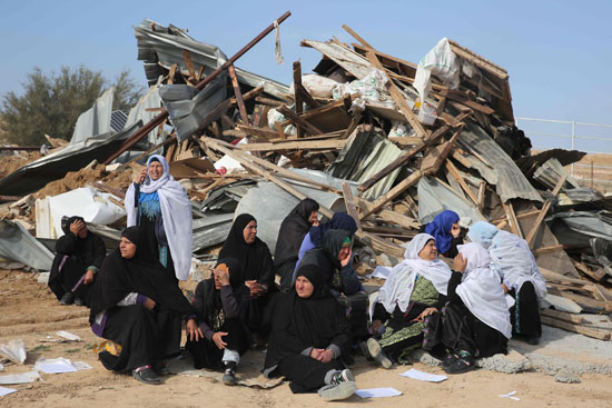 نساء فلسطينيات أمام منازلهم بعد هدمهم من قبل قوات الاحتلال