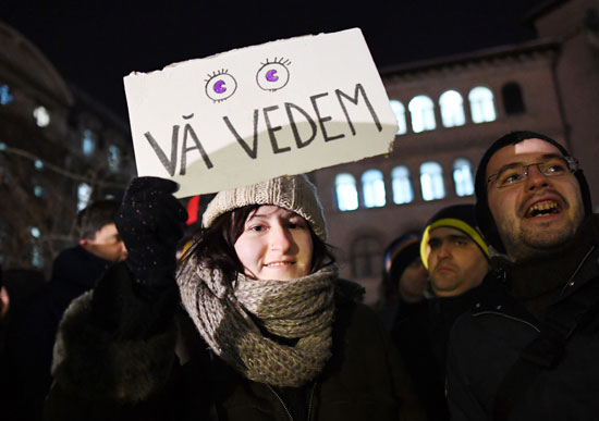 متظاهرة رومانية ترفع لافته ضد الفساد والحكومة