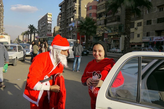 بابا نويل يلتقط صورة مع طفلة بشارع فيصل
