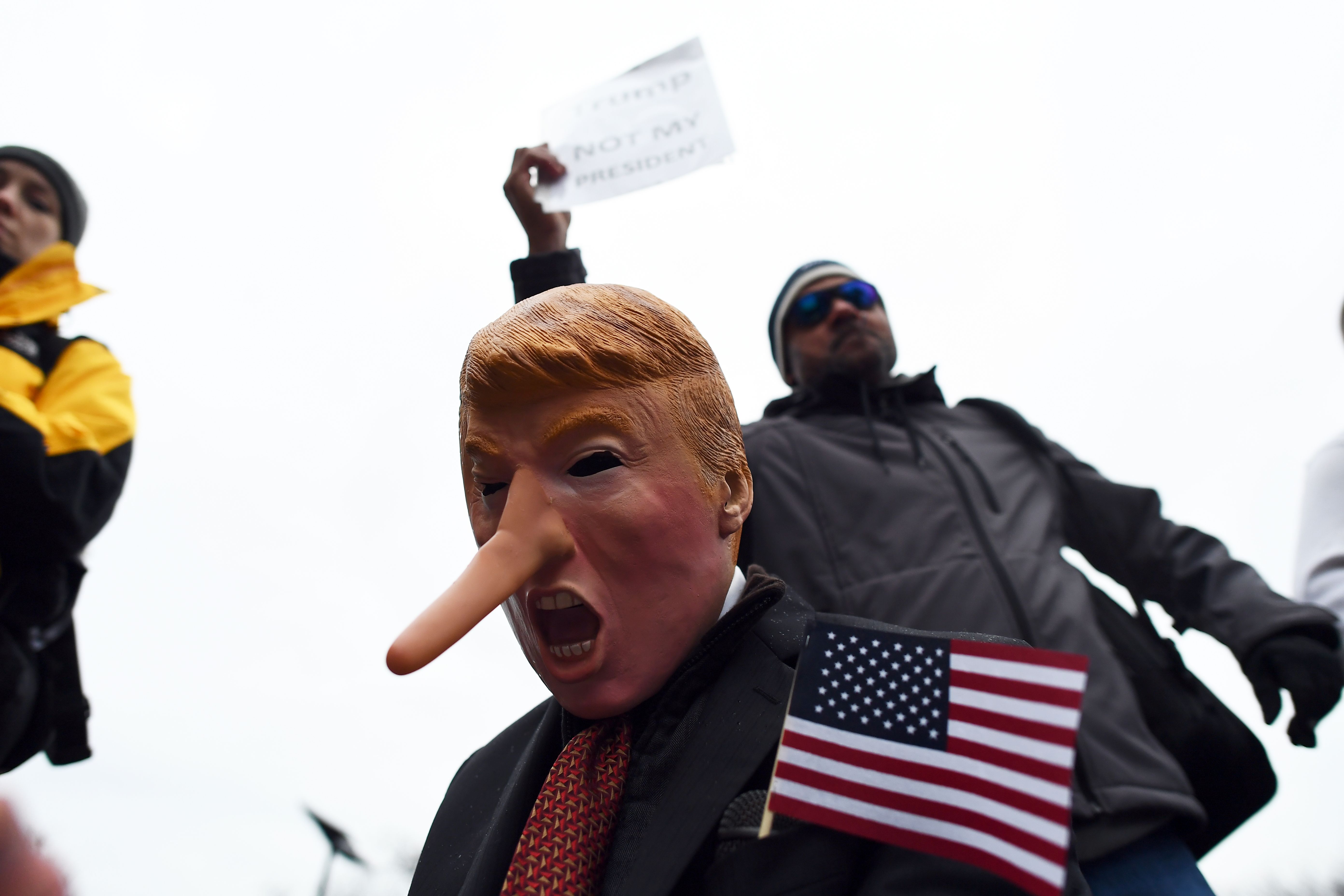 متظاهرون فى واشنطن يرتدون وجوه ساخرة من دونالد ترامب