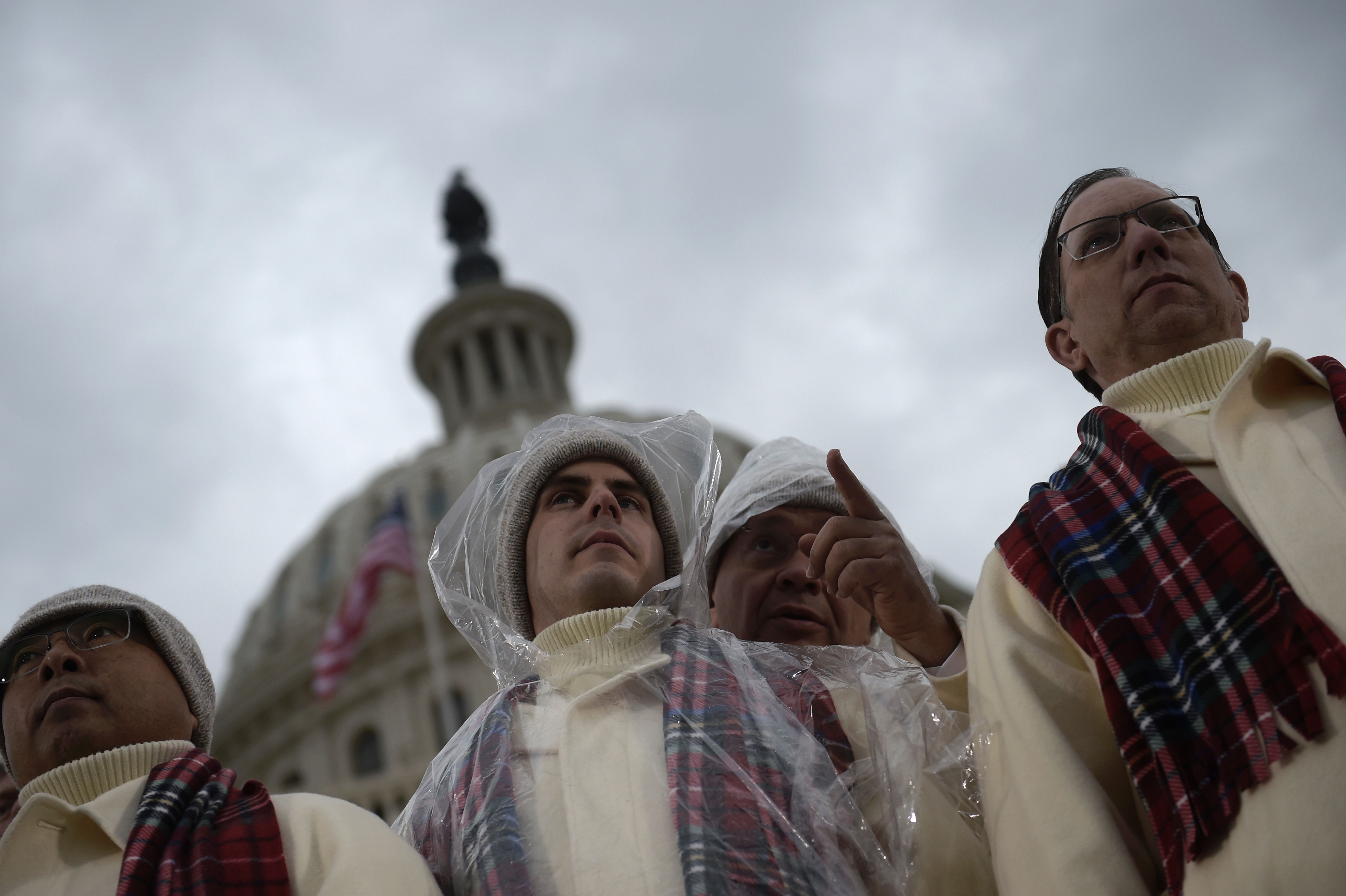 رجال الجوقة المرمونية يرتدون ملابس بلاستيكية لحمايتهم من الأمطار فى واشنطن