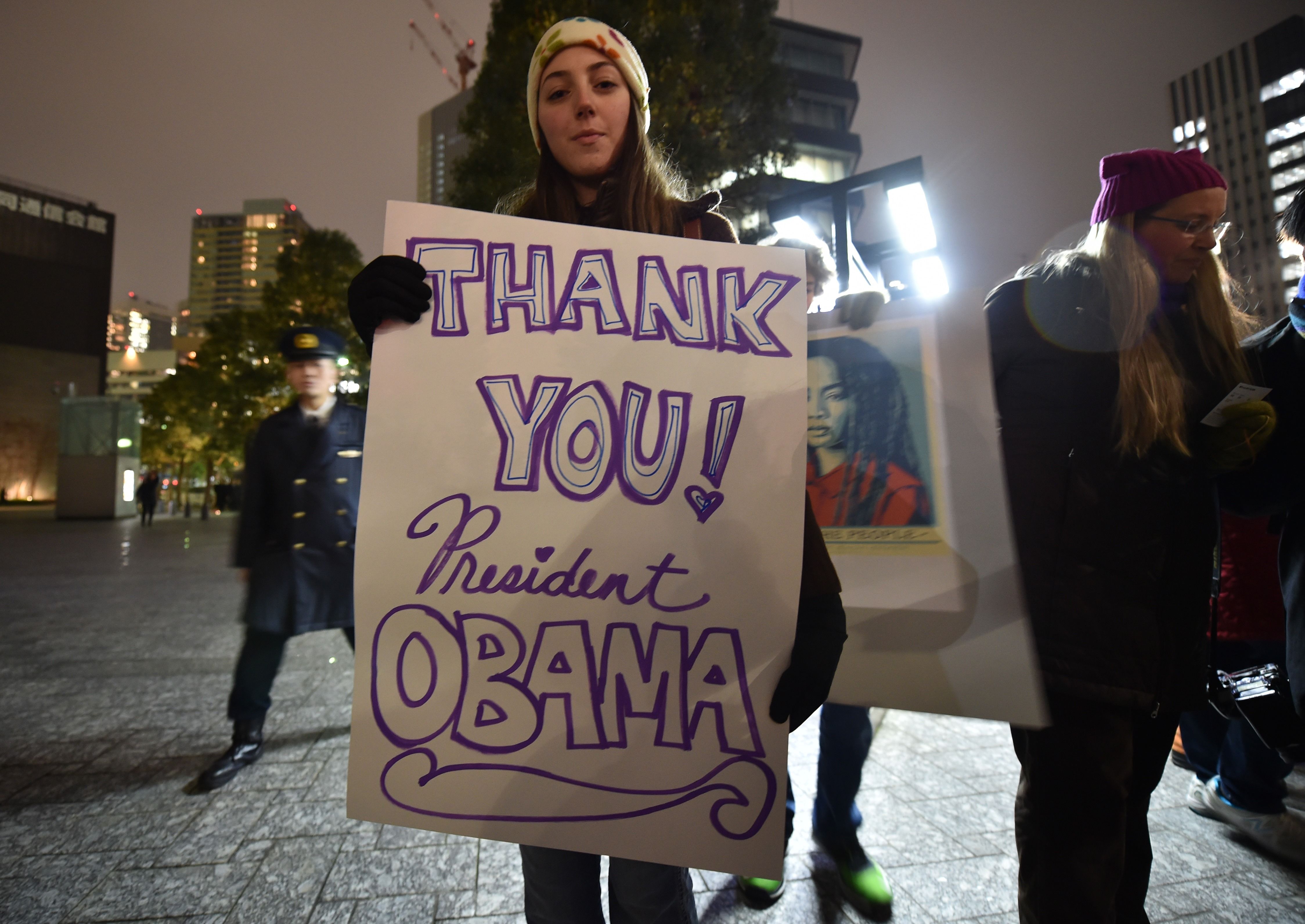 فتاة تحمل لافته مكتوب عليها شكرا أوباما خلال مسيرة فى طوكيو