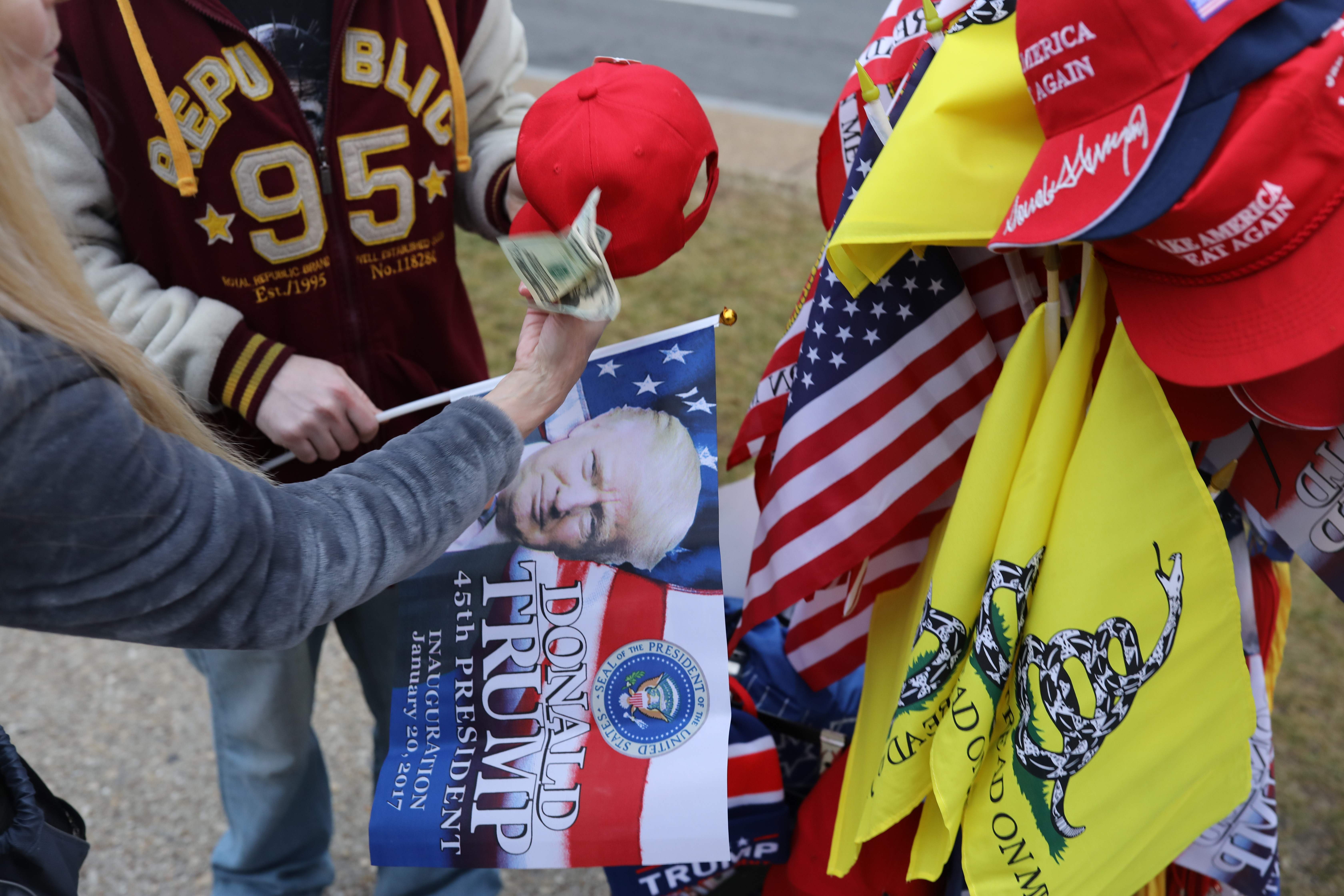 بائعون كابات وصور ترامب وأعلام أمريكا أمام مبنى الكابيتول فى واشنطن