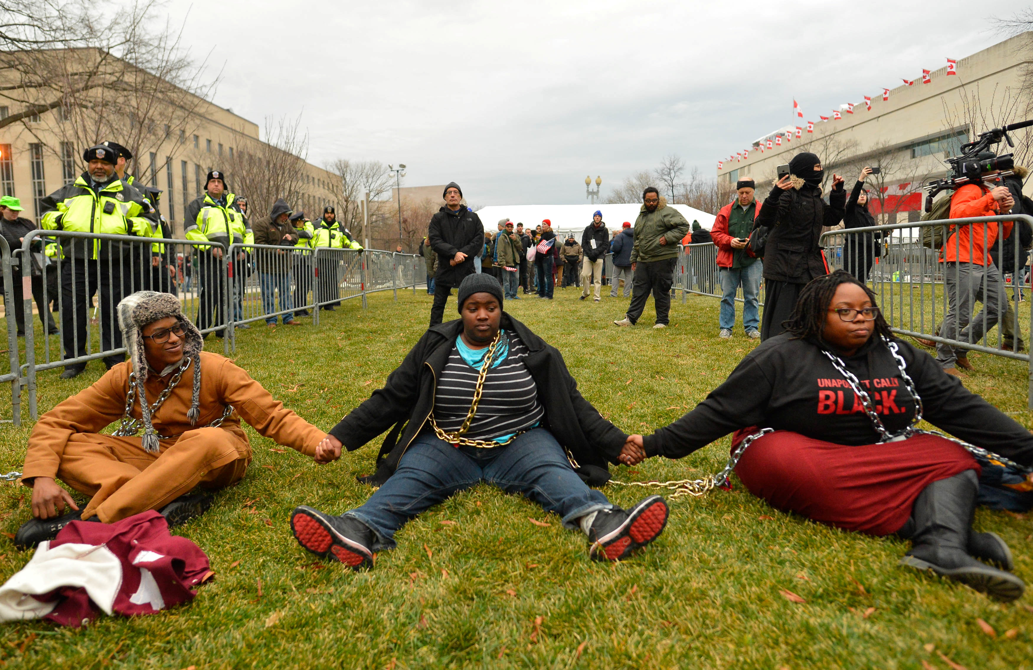 متظاهرون يجلسون على الأرض فى واشنطن بمسيرة مناهضة لدونالد ترامب
