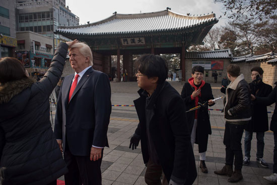 سيدة تمسح على رأس تمثال من الشمع لدونالد ترامب فى كوريا الجنوبية