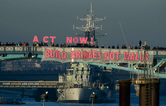 لافتات تطالب دونالد ترامب ببناء الجسور وليس بناء الجدران