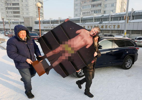 الفنان الروسى يحمل المجسم للرئيس الأمريكى وهو عاريًا قبل عرضه