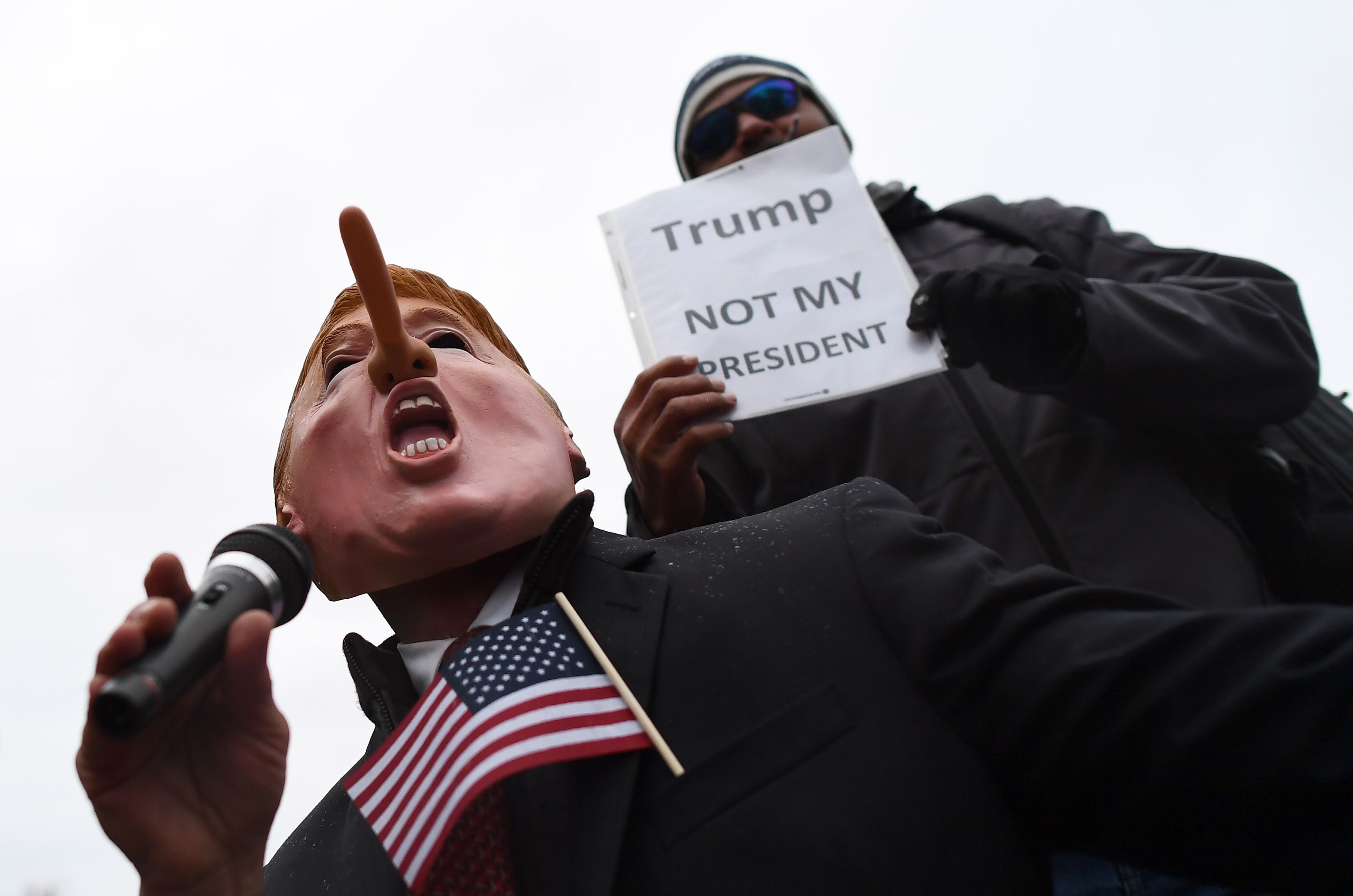متظاهر فى واشنطن يحمل لافتة مكتوب عليها ترامب ليس رئيسى