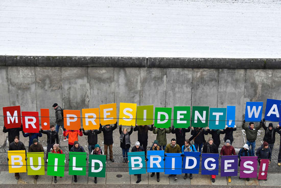 لافتات مكتوب عليها سيدى الرئيس الجدران تقسم ابنى الجسور