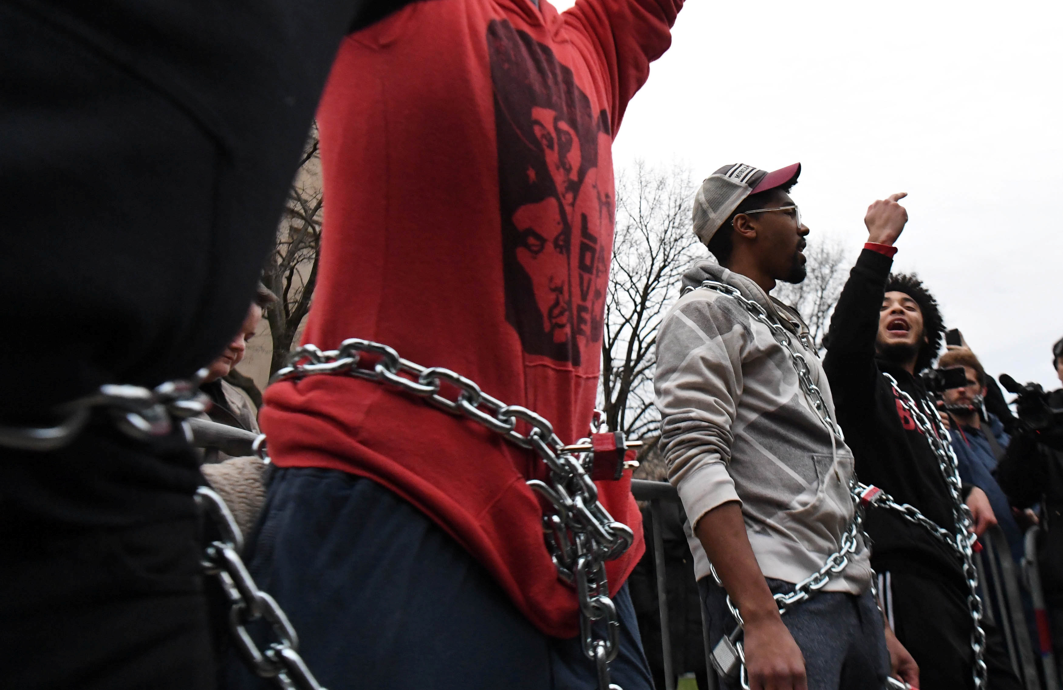 شباب يقيدون أنفسهم بالسلاسل الحديدية فى مسيرة ضد ترامب بواشنطن