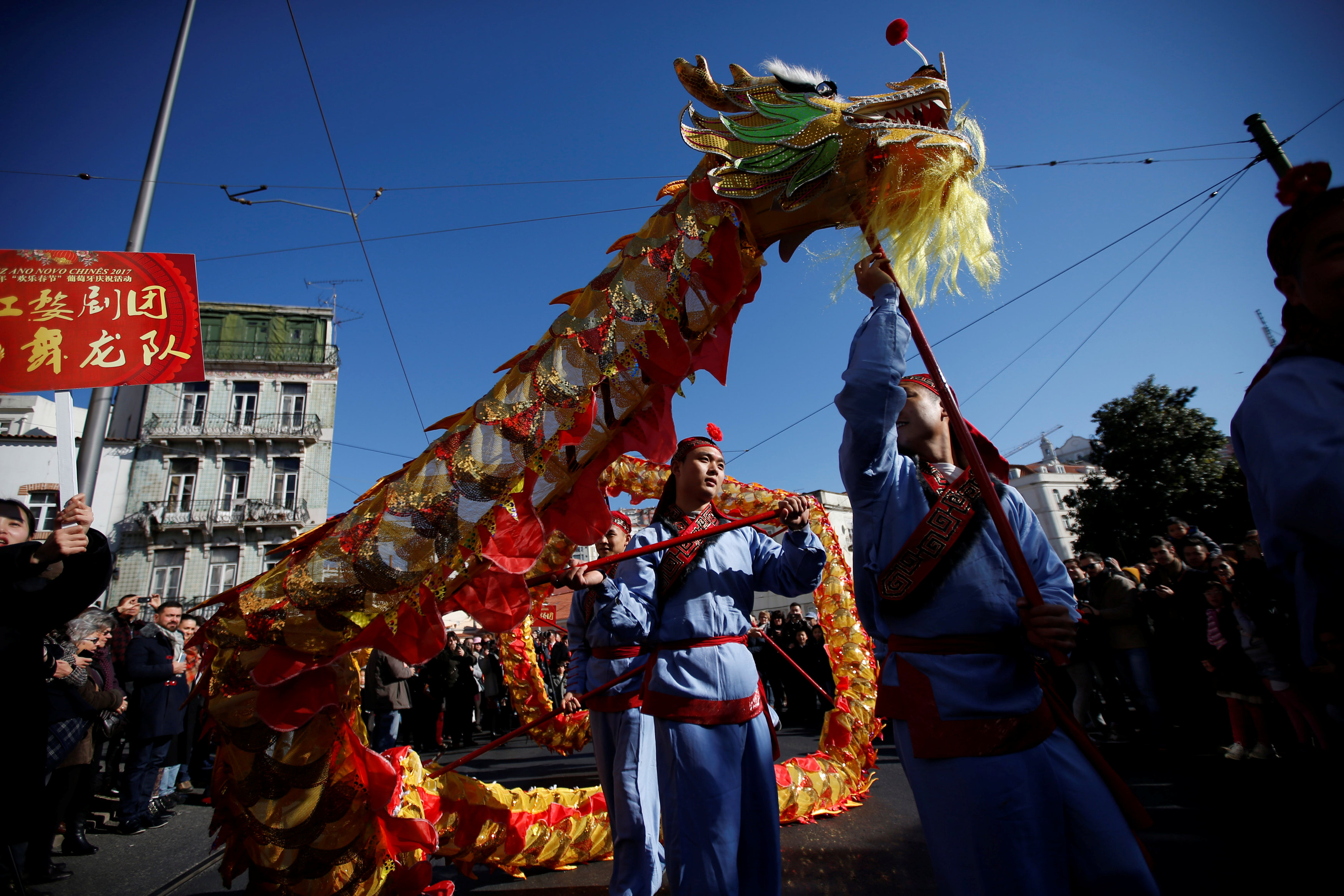 رجل يحمل دمية تنين فى احتفالات السنة الصينية الجديدة بالبرتغال