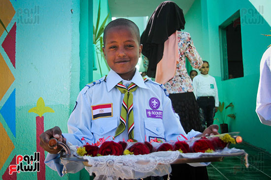 	أحد التلاميذ بمجمع مدارس الناموس يقدم الورود للزوار 