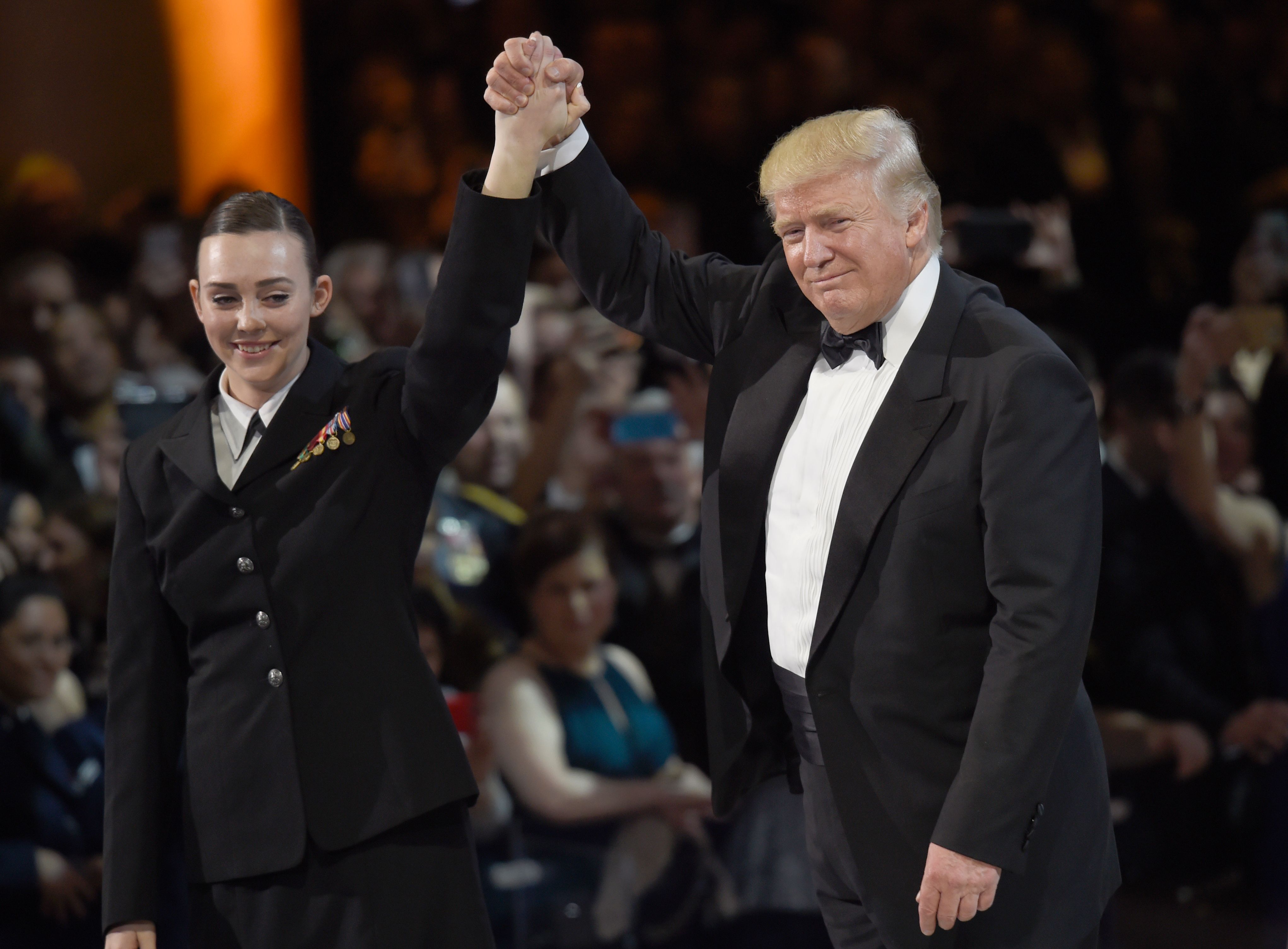 ترامب يحيى الجمهور مع أحد ضابطات القوات الأمريكية
