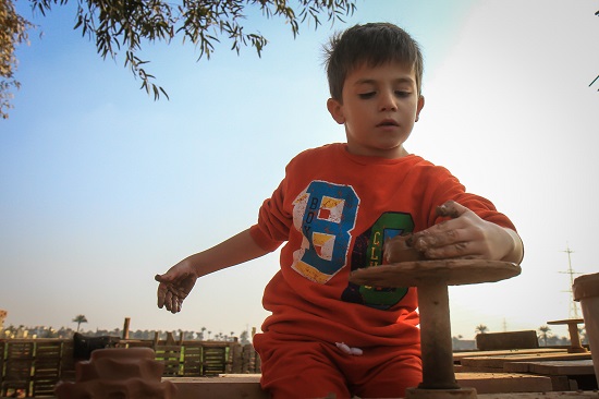 طفل يلعب بالفخار