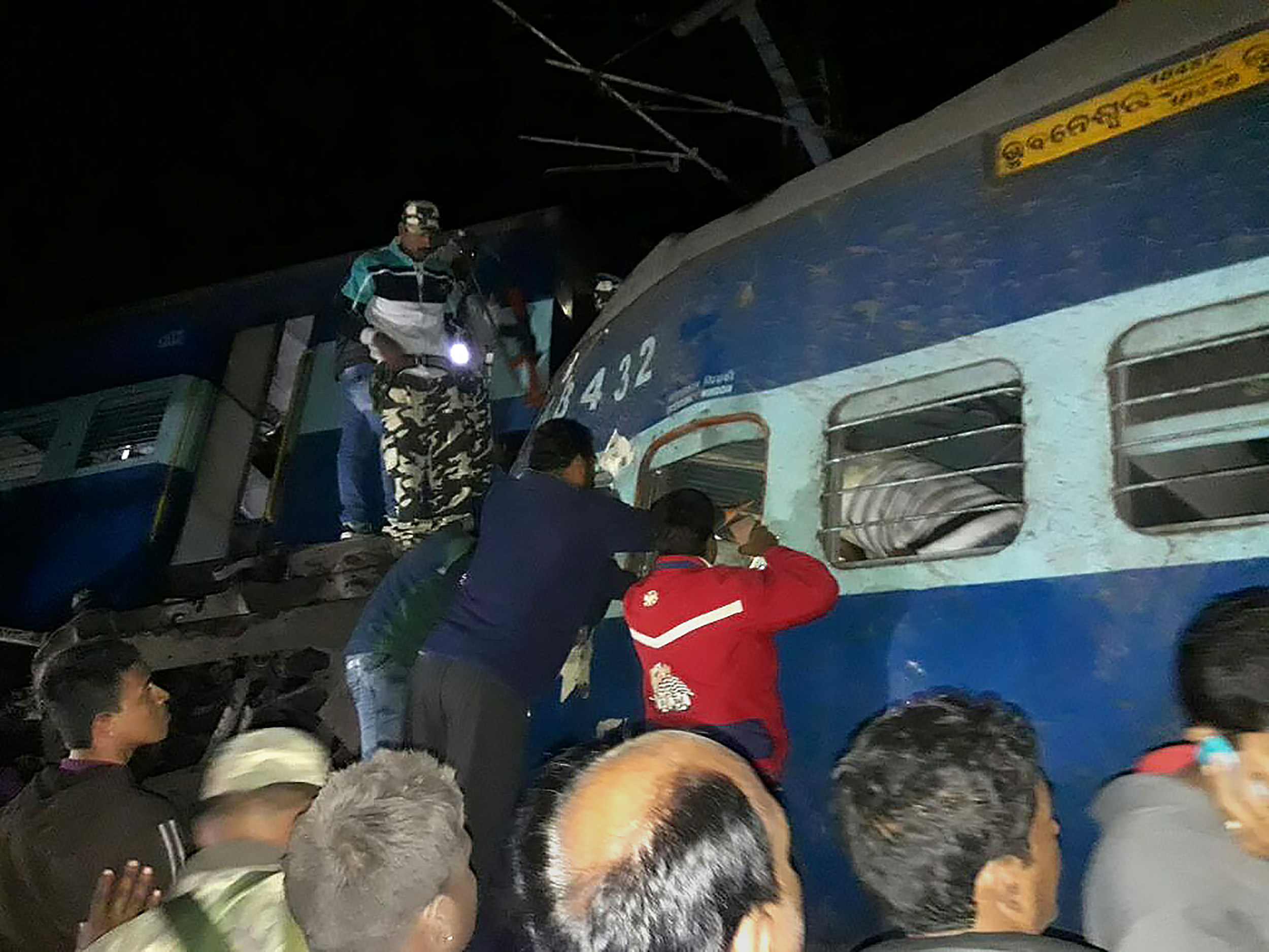 مواطنون وقوات الانقاذ فى الهند يبحثون عن الضحايا داخل عربات القطار - أ ف ب