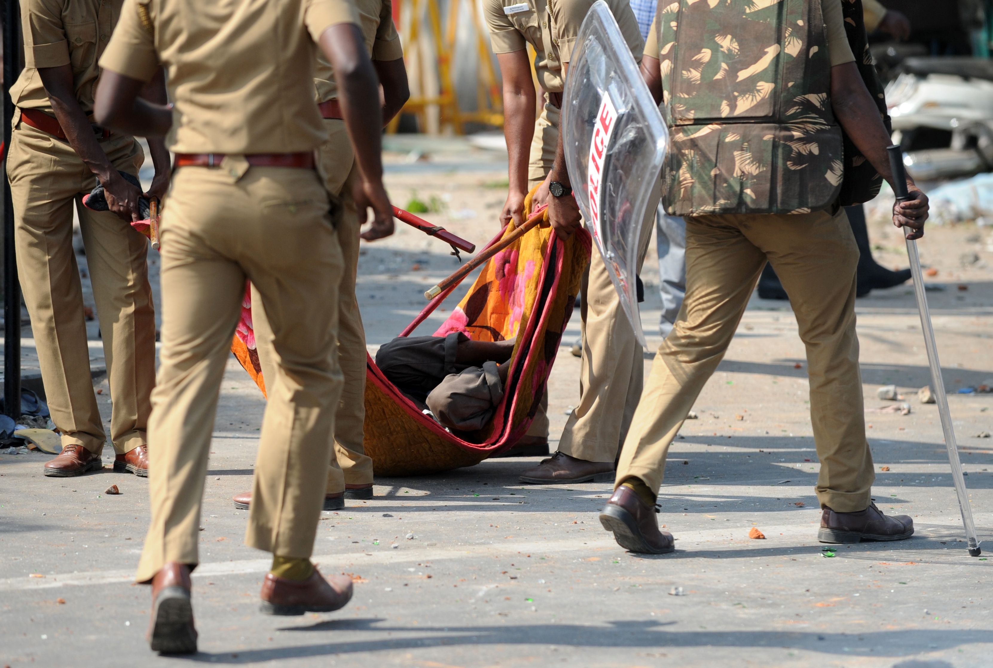 الشرطة تحمل متظاهرًا عقب إصابته بحالة إغماء فى الهند