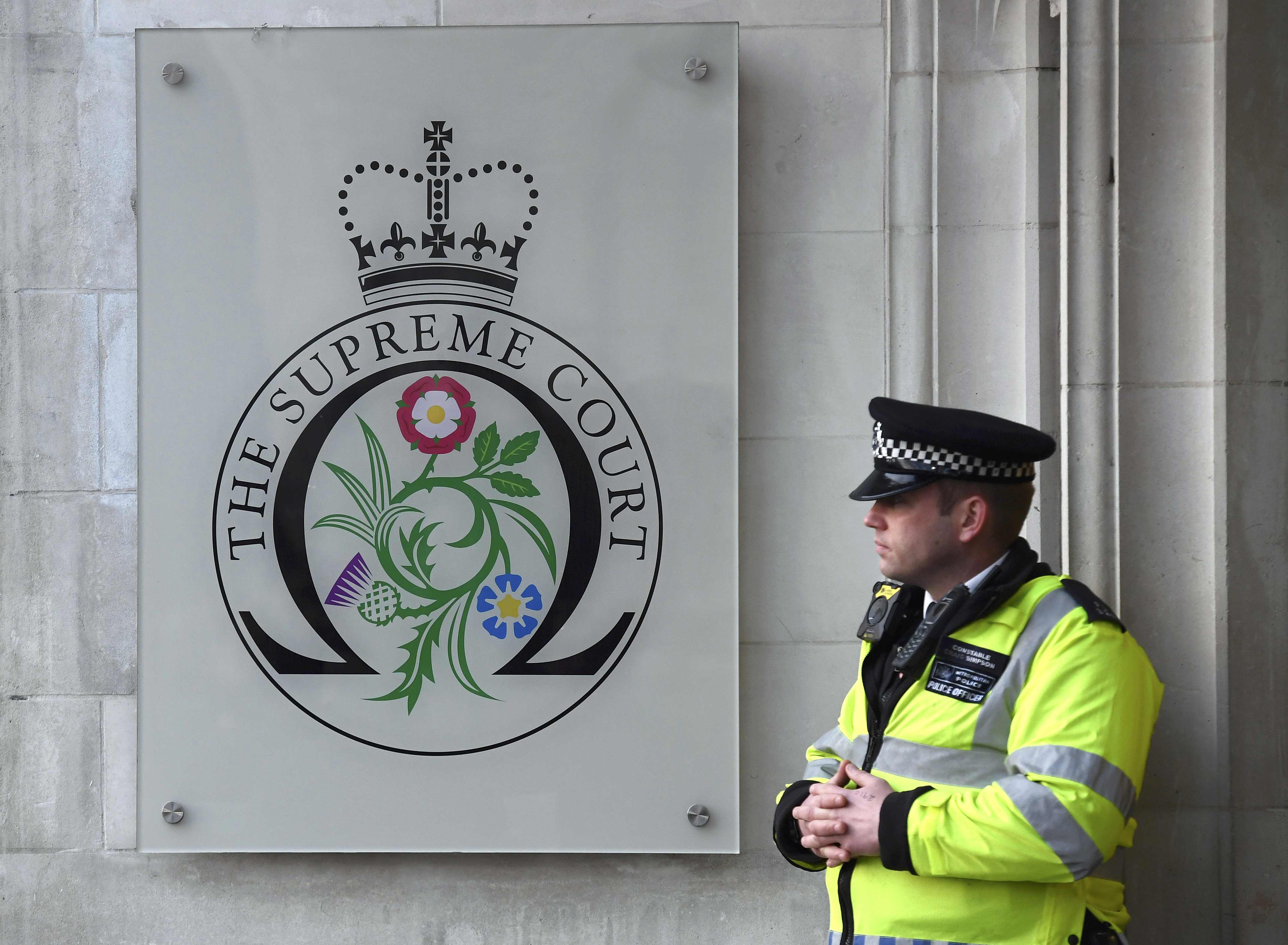 رجل شرطة يحرس باب المحكمة العليا البريطانية