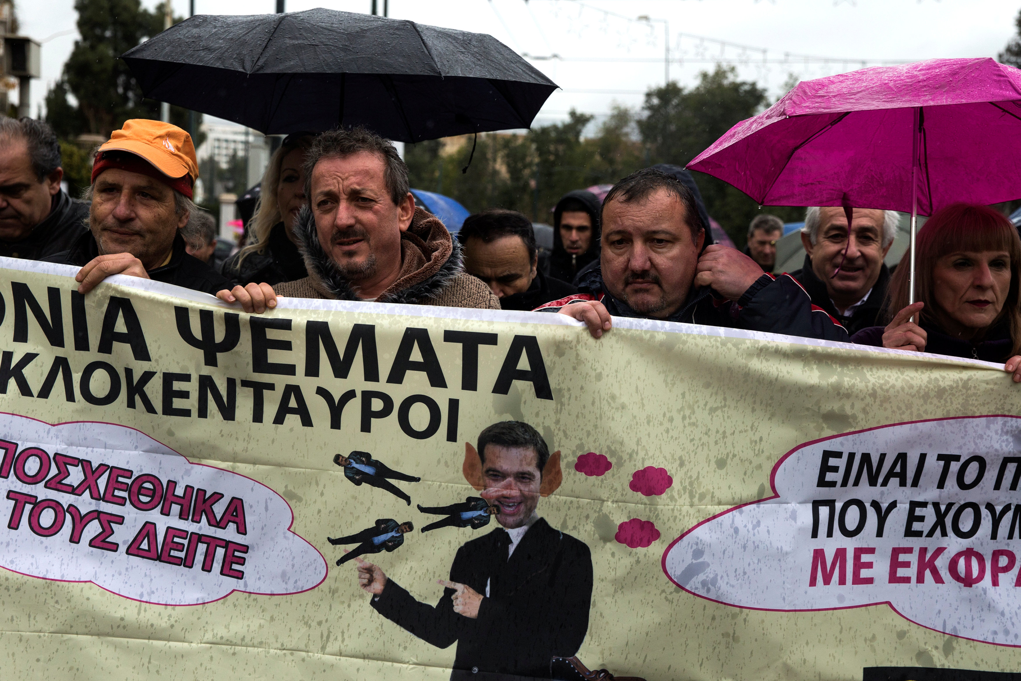 متظاهرون يونانيون يحملون لافتات تهاجم رئيس الوزراء اليونانى أليكسيس تسيبراس