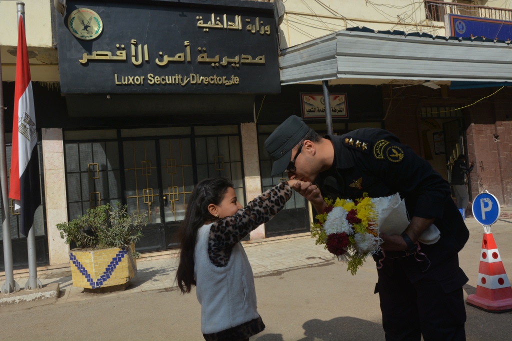 1- طلاب مدرسة أحمس الإبتدائية يوزوعون الورود والحلوي علي الشرطة بالأقصر
