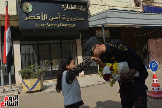 طلاب مدرسة أحمس الابتدائية يوزوعون الورود والحلوى على الشرطة بالأقصر