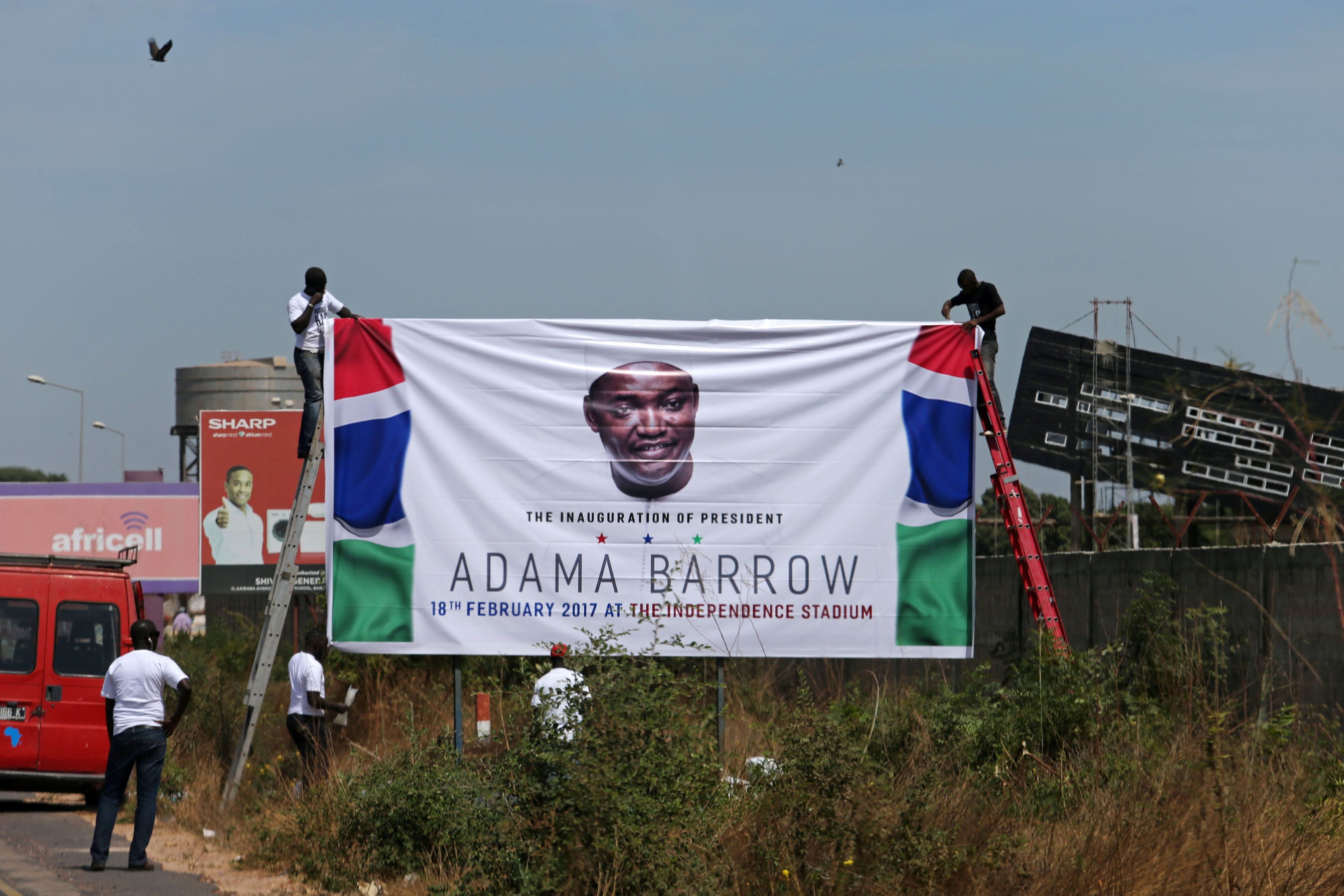 أنصار رئيس جامبيا الجديد أداما بارو يضعون لوحة إعلانية للتأييده