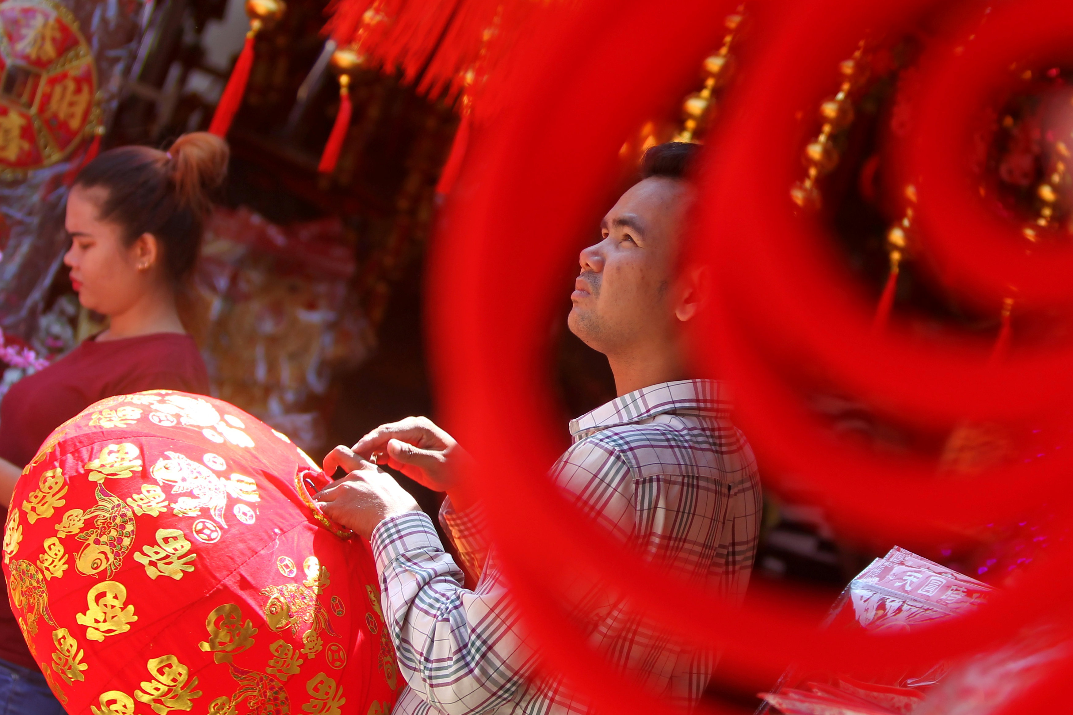 مواطن يشترى الفوانيس المضاءة للاحتفال بالسنة الصينية الجديدة فى كمبوديا